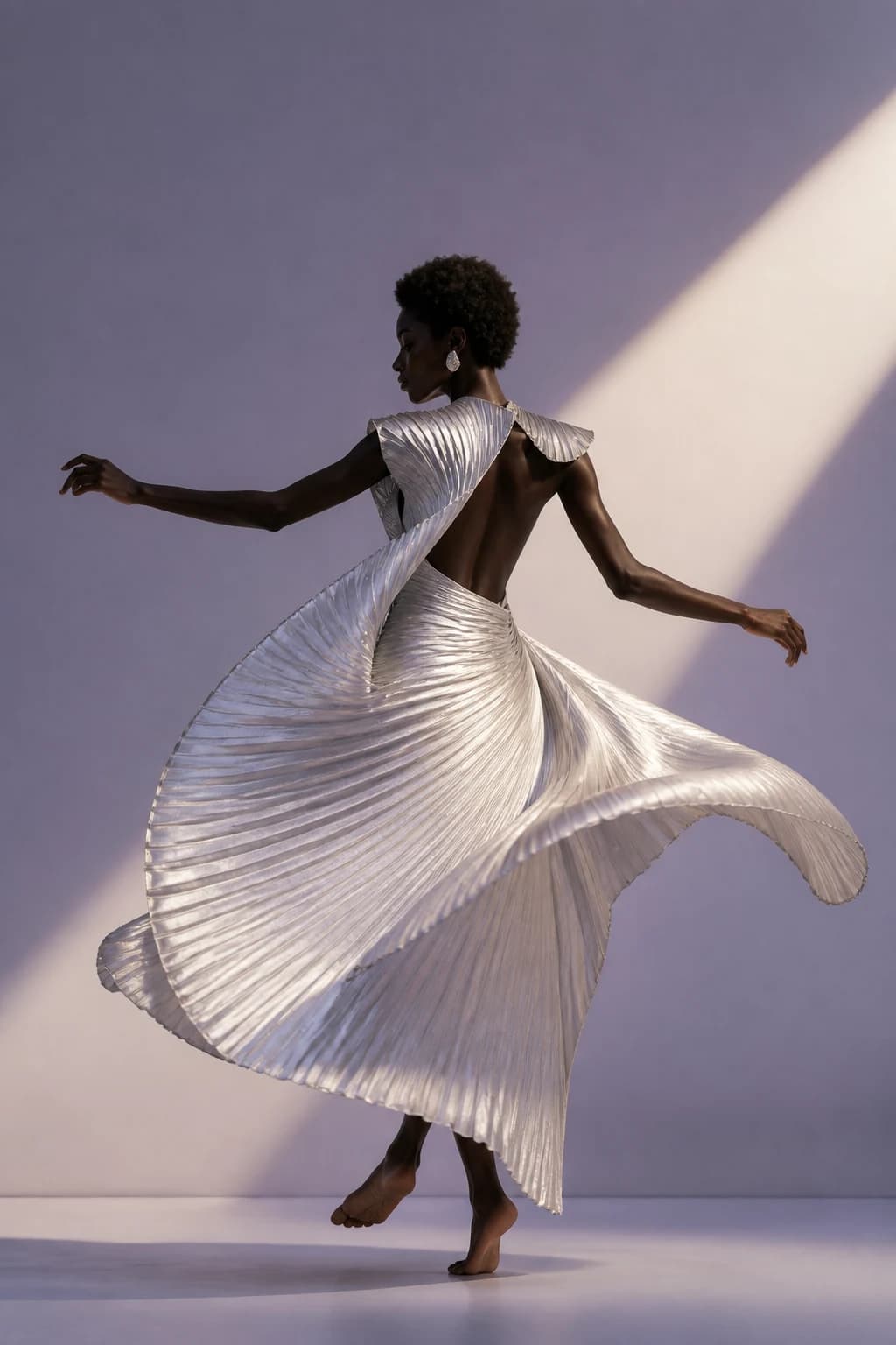 Vertical fashion editorial with a dancer in a sculptural pleated garment