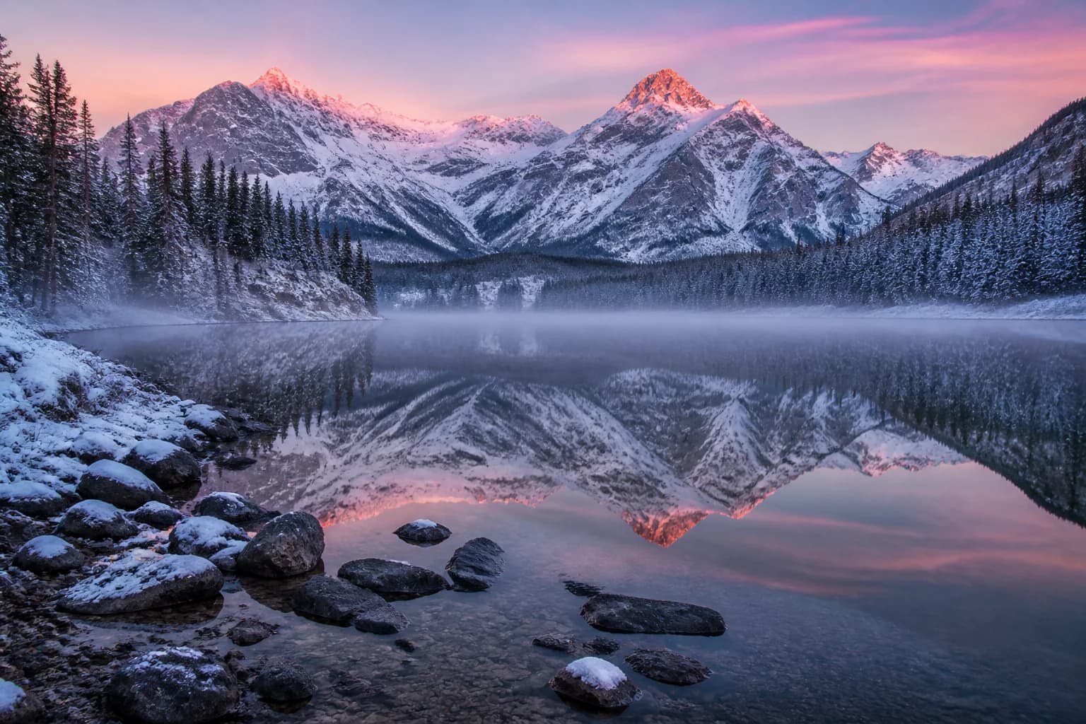 Alpine lake transformed from summer into an early winter dawn
